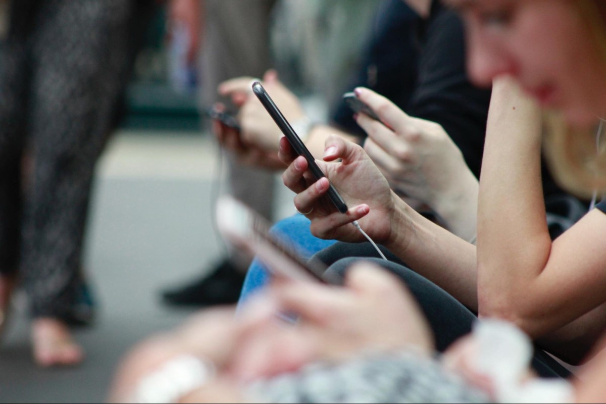 a row of people using phones