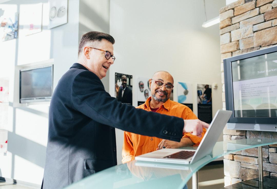Two men discussing sales enablement technology in an office setting.
